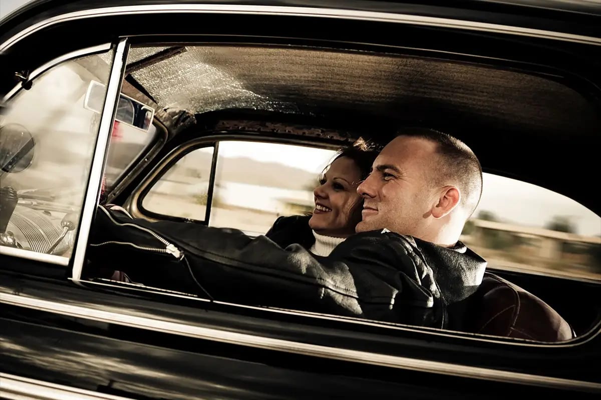 Happy couple enjoying driving their car following panel beating repairs